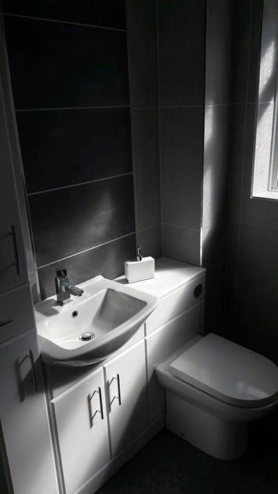 black tiled bathroom with white sink and toilet